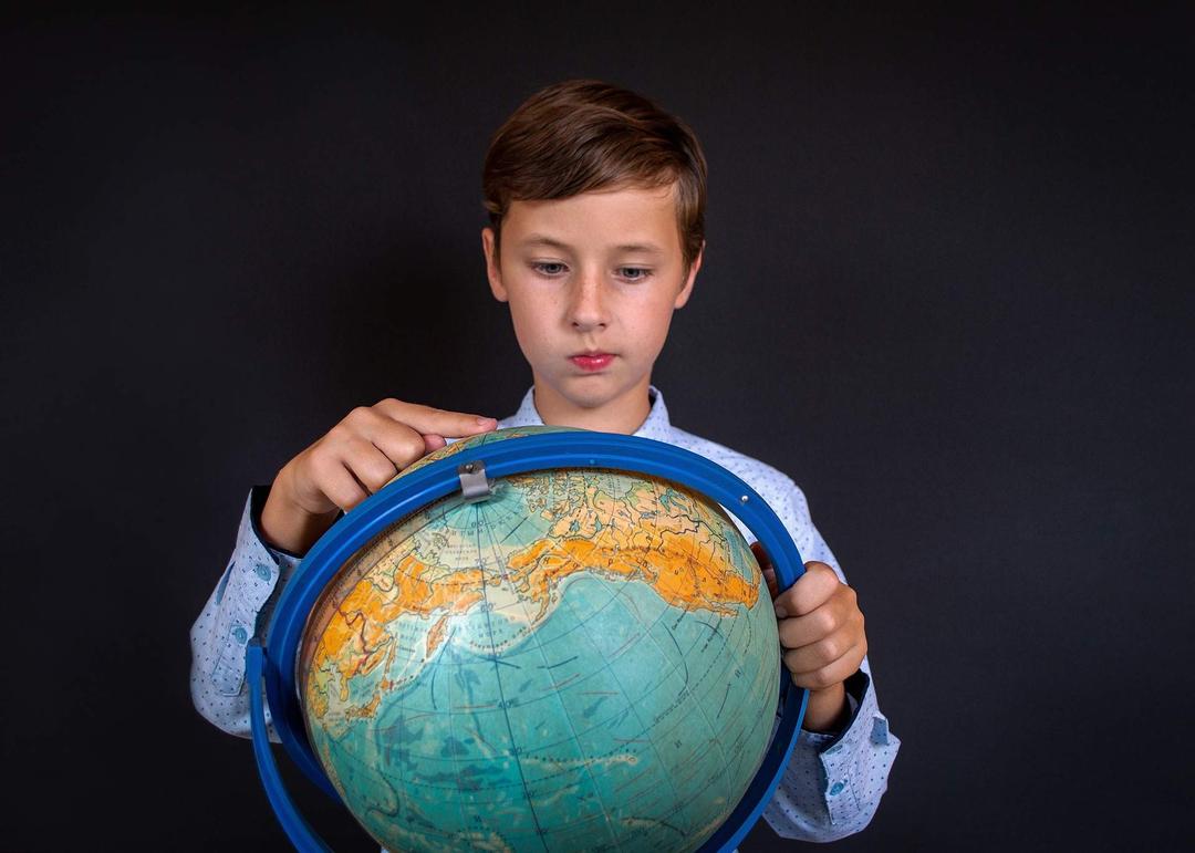 Kid pointing at globe